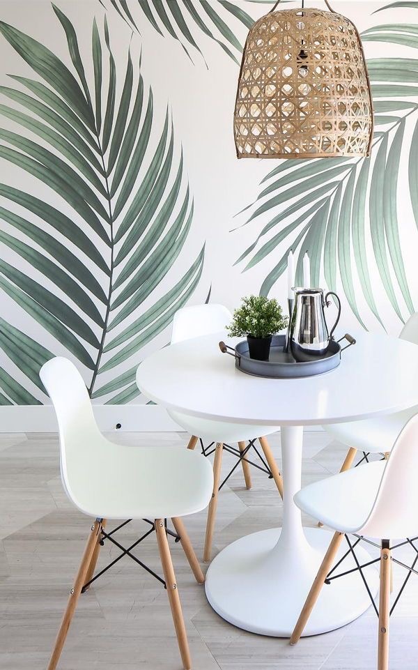 Breakfast nook with tropical palm leaf wallpaper accent wall and tulip table — a bold patterned accent wall idea.