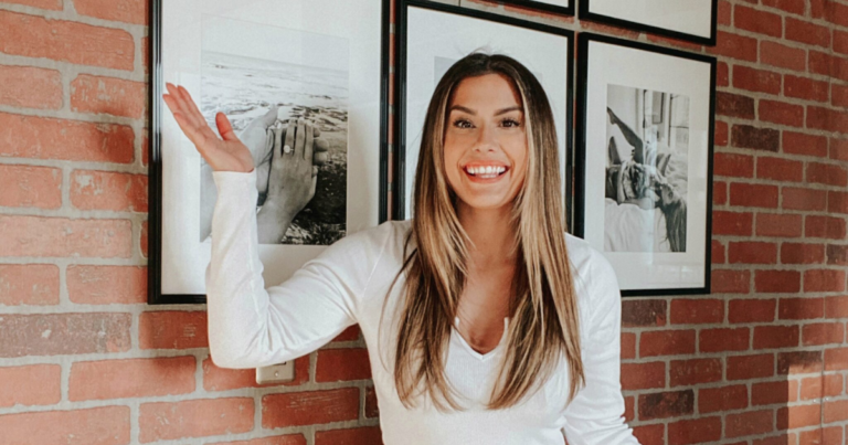 Liz Lovery in front of an exposed brick accent wall — designer's guide to 15 accent wall ideas to elevate any room.