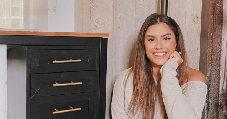 Liz Lovery sitting next to her finished IKEA Alex Drawers DIY with brass hardware