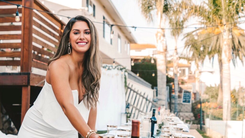 Liz Lovery setting a table for an outdoor gathering at golden hour.