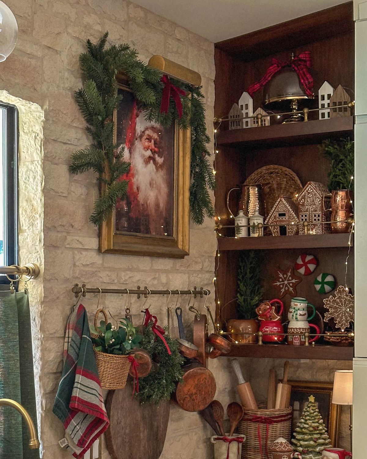 Brass gallery rail wood-panel shelves styled for the holidays with gingerbread houses, copper mugs, and twinkle lights
