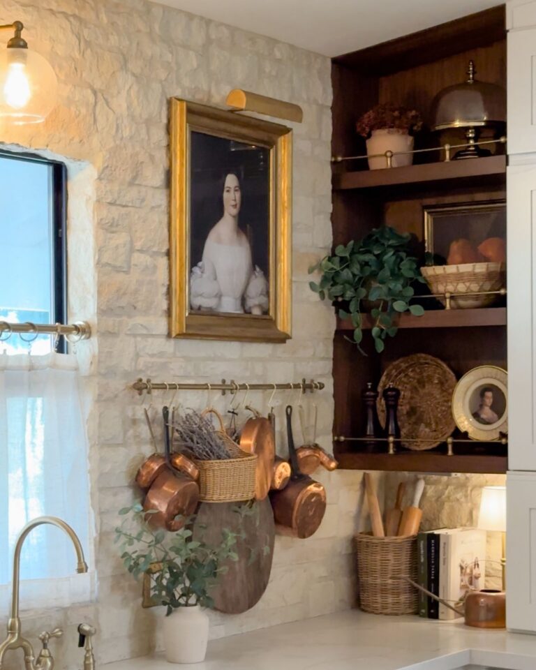 Brass gallery rail wood-panel shelves styled with copper pots, dried hydrangea, baskets, and framed art