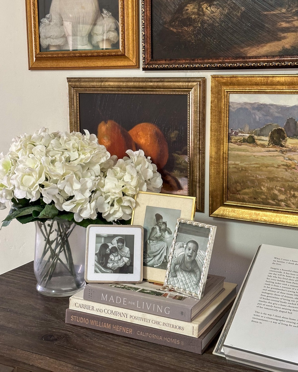 black and white family photos in gold and silver frames displayed on coffee table books